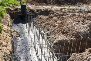 first stage of pouring the Foundation for a new building with cement and reinforcements with steel bars, wire rod and inspection well